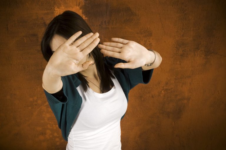 Woman hiding her eyes, fear holding her back